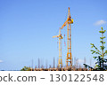 Construction cranes lifting materials at modern building site outdoors 130122548