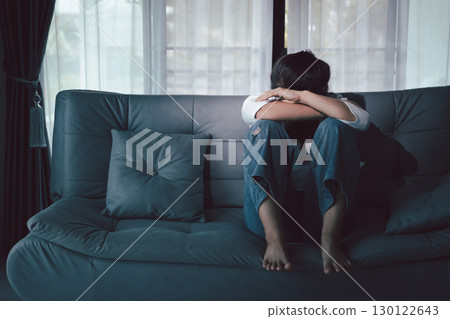 Depression woman sit on sofa. Despair sorrow person sitting alone and hugging knees, Boring sad upset frustrated stressed. struggling to find hope amid suffocating burden. mental health concept. Depression woman sit on sofa. Despair sorrow person sitting alone and hugging knees, Boring sad upset frustrated stressed. struggling to find hope amid suffocating burden. mental health concept. 130122643