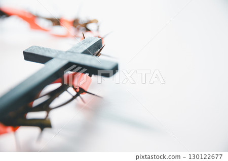 Cross and crown of thorns, often seen in gold crucifix symbols, represent the sacrifice of Jesus Christ-central to Easter message and the foundation of faith in the Christian religion. 130122677