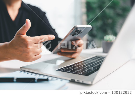 Closeup of woman holding smartphone hand shows using mobile phone technology browse online shopping, social media, engaging in fast-paced world of cyberspace. online shopping, social media network 130122932