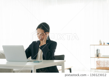 A woman troubled in front of a personal computer 130123012