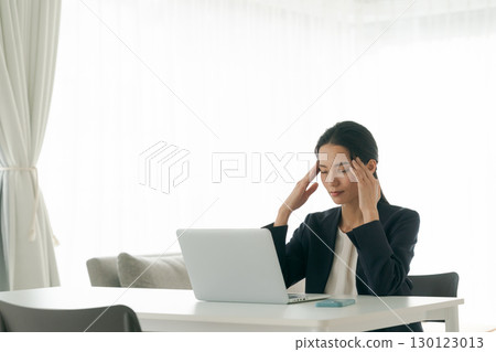 A woman troubled in front of a personal computer A woman troubled in front of a personal computer 130123013