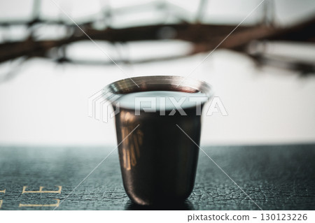 Christianity, holy communion ceremony is sacred act of worship and faith, where bread and wine in chalice symbolize body and blood of Christ in the religious eucharist tradition. 130123226