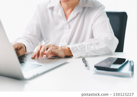 Close-up businesswoman using smart mobile phone at office table, female student is home studying online e-learning, searching for information on internet, engaging with social networks. Close-up businesswoman using smart mobile phone at office table, female student is home studying online e-learning, searching for information on internet, engaging with social networks. 130123227
