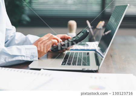 Office businesswoman hand to operate calculator analyzing financial data, counting costs on desk. accounting, financial analysis for business budget planning, calculation support, finance management. 130123716