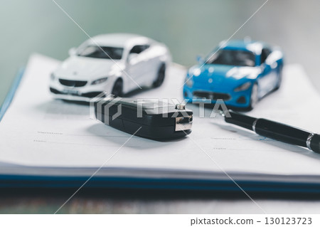 Client legal contract and finance document for business deal involving vehicle, agreements cover car loan, insurance, investment terms, with car key handed over to complete transaction. Client legal contract and finance document for business deal involving vehicle, agreements cover car loan, insurance, investment terms, with car key handed over to complete transaction. 130123723