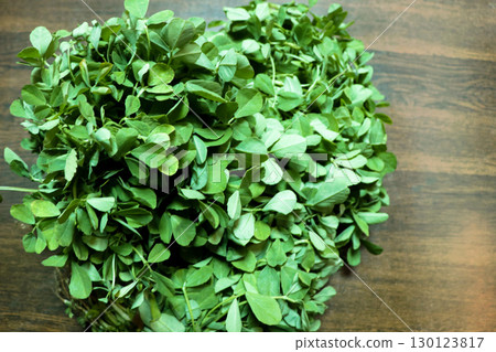 Fresh Fenugreek Leaves (Methi) on Wooden Surface 130123817
