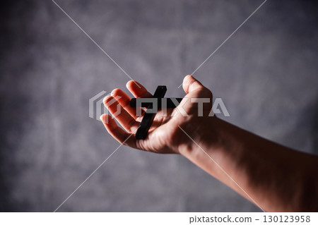 Christian woman lifts her hand in worship to pray, hope, faith, and deep belief in God defines core concept of religion. Praying hands with faith in religion, belief in God. Power of hope or love. 130123958