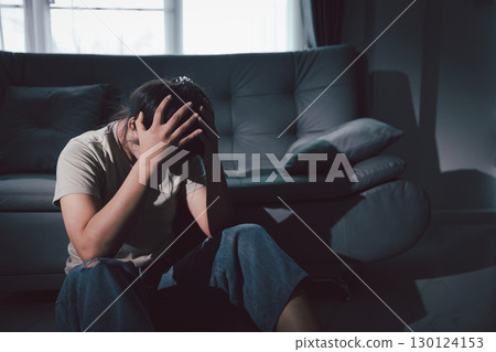 Despair sorrow person in empty dark room, Depressed young woman covering face with hands. Young woman coping with distress covering face. mental health concept. Boring sad upset frustrated stressed. 130124153