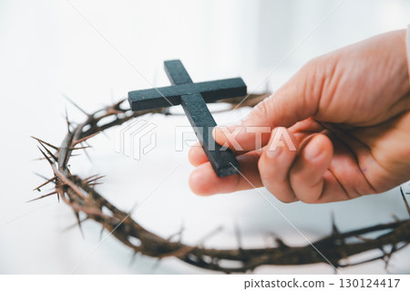Crown of cross with hand. Crown of thorns on head and hands nailed to cross, Jesus Christ made ultimate sacrifice, symbolizing faith, belief and profound religious and spiritual meaning of Easter. Crown of cross with hand. Crown of thorns on head and hands nailed to cross, Jesus Christ made ultimate sacrifice, symbolizing faith, belief and profound religious and spiritual meaning of Easter. 130124417