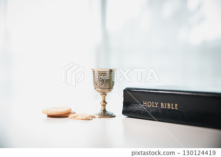 Christianity, holy communion ceremony is sacred act of worship and faith, where bread and wine in chalice symbolize body and blood of Christ in the religious eucharist tradition. 130124419