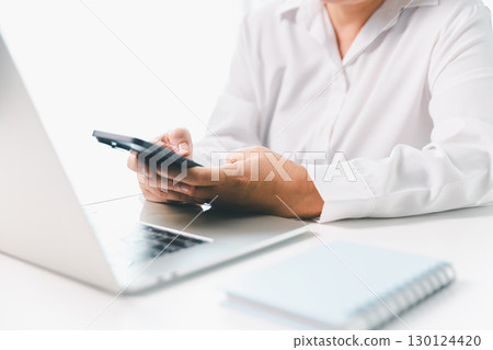 Close-up businesswoman using smart mobile phone at office table, female student is home studying online e-learning, searching for information on internet, engaging with social networks. 130124420