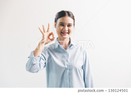 Asian woman rejoicing, looking happy, champion, fist pump gesture, standing over white background. young woman had happy, positive expression on her face, highlighted by bright smile. Asian woman rejoicing, looking happy, champion, fist pump gesture, standing over white background. young woman had happy, positive expression on her face, highlighted by bright smile. 130124501