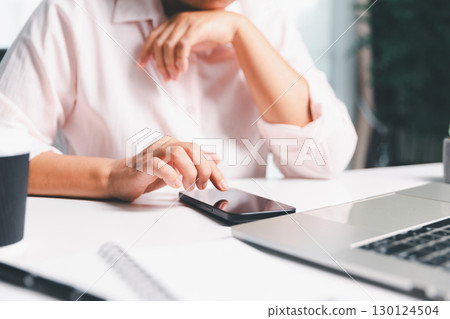 Closeup of woman holding smartphone hand shows using mobile phone technology browse online shopping, social media, engaging in fast-paced world of cyberspace. online shopping, social media network 130124504