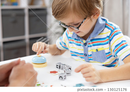 Child Engaged in Educational Activity with Letter Blocks and Bell Child Engaged in Educational Activity with Letter Blocks and Bell 130125176