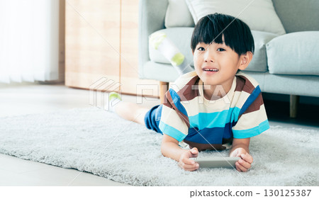 Boy playing with a smartphone Boy playing with a smartphone 130125387