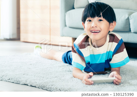 Boy playing with a smartphone 130125390