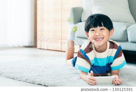 Boy playing with a smartphone 130125391