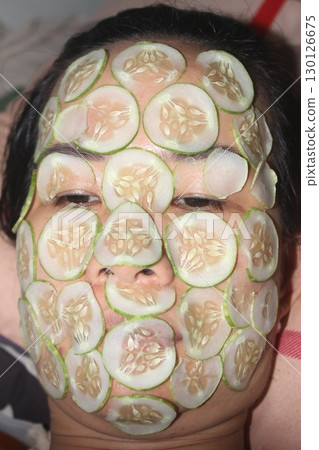 August 18, 2025. Chu Van An, Hai Phong, Viet Nam. girl beautifies facial skin with cucumber August 18, 2025. Chu Van An, Hai Phong, Viet Nam. girl beautifies facial skin with cucumber 130126675