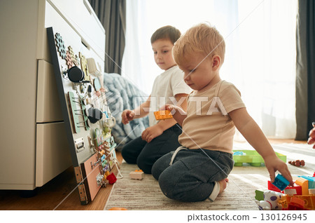 Two brothers are playing with constructor with bunch of objects at home 130126945
