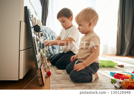 Two brothers are playing with constructor with bunch of objects at home 130126946