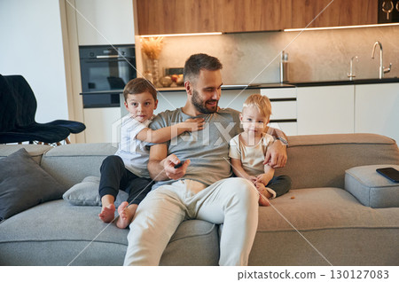 Conception of relaxation. Father with two baby boys is sitting at sofa Conception of relaxation. Father with two baby boys is sitting at sofa 130127083