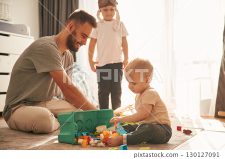 Construction toys. Father is playing with two little boys on the floor 130127091