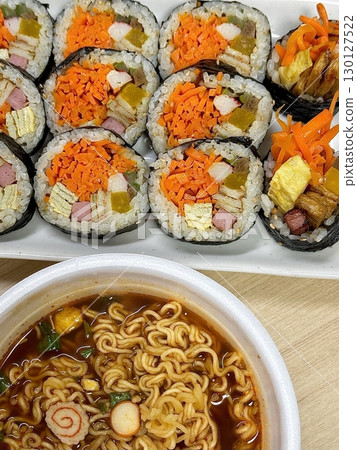Kimbap and Ramyun, a perfect Korean combo! Enjoy savory rice rolls with vegetables, meat, and pickles alongside a flavorful bowl of spicy, comforting ramen. A satisfying meal for any time of day. 130127522