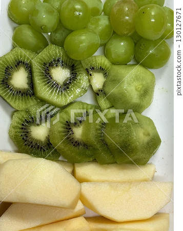 A vibrant seasonal fruit platter with a colorful assortment of freshly sliced fruits. Perfectly ripe and juicy, it offers a refreshing mix of flavors for any occasion. 130127671