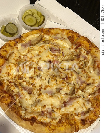 Cheesy pizza topped with golden french fries, combining crispy potato goodness with gooey, savory delight. A fun and indulgent twist on two favorite comfort foods. 130127682