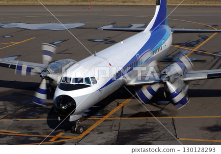 A propeller plane seen from the front, arriving and heading towards the spot 130128293