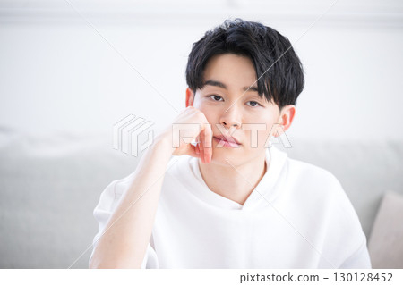 Close-up of a man with a thoughtful expression resting his chin on his hands 130128452