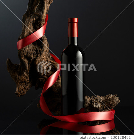Bottle of red wine on a black reflective background. Bottle of red wine on a black reflective background. 130128491