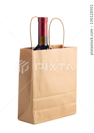 Bottle of red wine in paper bag isolated on a white background. 130128501