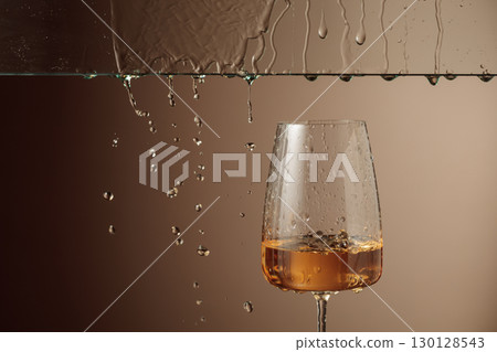 White wine flows down into a glass. 130128543