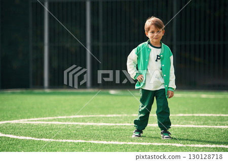 Full height photo of little boy on green field 130128718