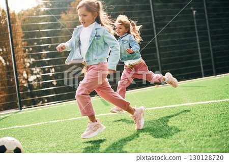 Active weekend. Kids are having fun on the green soccer field together 130128720