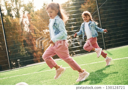 Active weekend. Kids are having fun on the green soccer field together 130128721