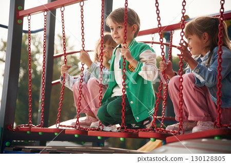 Two girl and one boy. Kids are having fun on the playground Two girl and one boy. Kids are having fun on the playground 130128805
