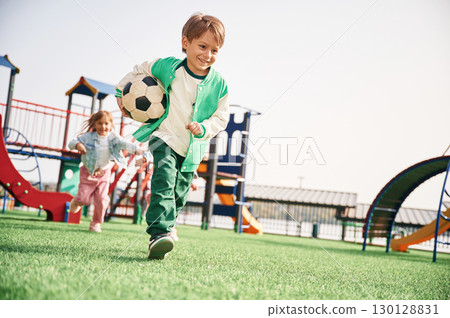 Boy is with soccer ball. Kids are having fun on the playground 130128831