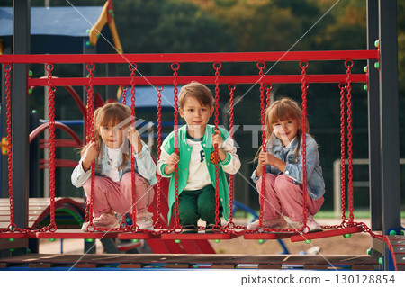 One boy and two girls. Kids are having fun on the playground 130128854