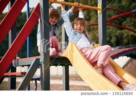On the playground slide. Kids are having fun On the playground slide. Kids are having fun 130128884