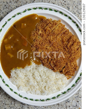 Crispy tonkatsu, a Japanese-style breaded and deep-fried pork cutlet, served with shredded cabbage and drizzled with savory sauce. A delightful balance of crunchy texture and juicy meat. 130129087