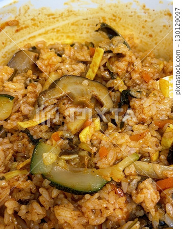 Bibimbap, a vibrant Korean rice dish topped with a variety of seasoned vegetables, gochujang, and a fried egg, often accompanied by sliced meat. Mixed together, it creates a flavorful and balanced. 130129097