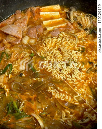 A hearty bowl of Budaejjigae (Korean Army Stew), filled with sausage, tofu, kimchi, and noodles in a spicy broth. This flavorful dish brings warmth and comfort, perfect for sharing. A hearty bowl of Budaejjigae (Korean Army Stew), filled with sausage, tofu, kimchi, and noodles in a spicy broth. This flavorful dish brings warmth and comfort, perfect for sharing. 130129129