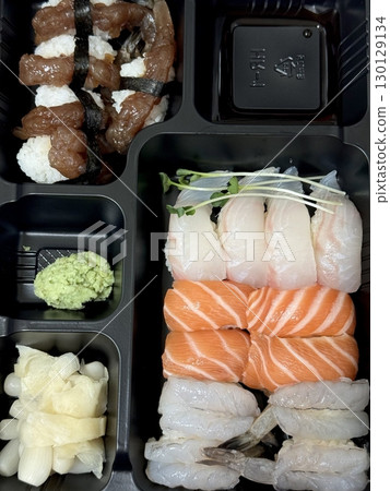 An assortment of fresh sushi, artfully arranged with a variety of toppings and vibrant colors. This traditional Japanese dish combines vinegared rice, seafood, and vegetables for an experience. 130129134