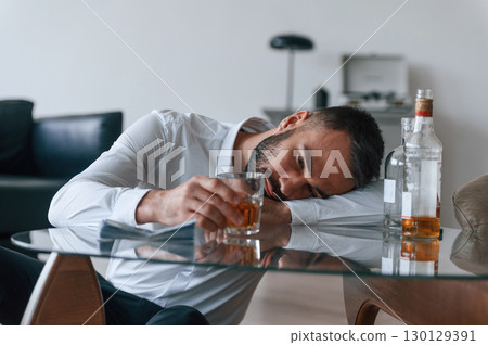 Life crisis. With whiskey. Upset young man drinker alcoholic is indoors 130129391