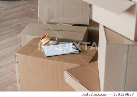 Boxes with scotch tape and notepad. Conception of moving to new house Boxes with scotch tape and notepad. Conception of moving to new house 130129657