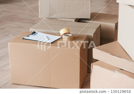 Boxes with scotch tape and notepad. Conception of moving to new house 130129658