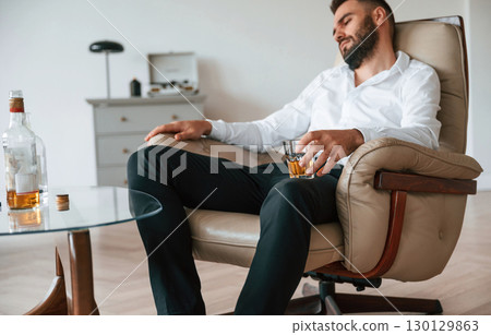 Feeling depressed. Upset young man drinker alcoholic is indoors Feeling depressed. Upset young man drinker alcoholic is indoors 130129863